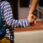 Mom holds her son's hand